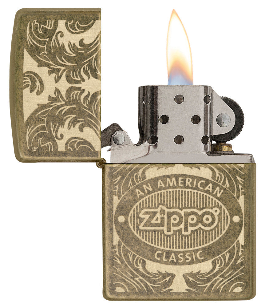 Briquet Zippo vue de face ouvert avec une flamme entouré d’un motif en filigrane gravé au laser qui montre le logo de Zippo et de "an american classic".