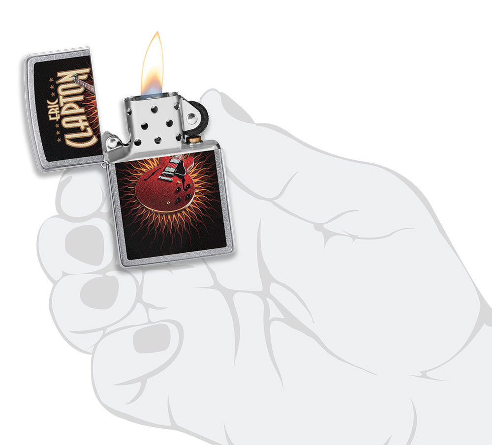 Zippo aansteker vooraanzicht chroom open en aangestoken met gekleurde afbeelding van een rode gitaar van Eric Clapton in stilistische hand