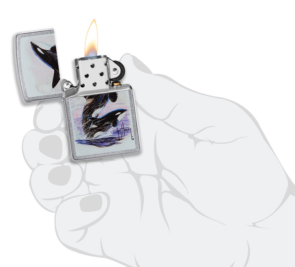 Zippo aansteker vooraanzicht chroom open en aangestoken met gekleurde afbeelding van twee orka's getekend door Guy Harvey in stilistische hand