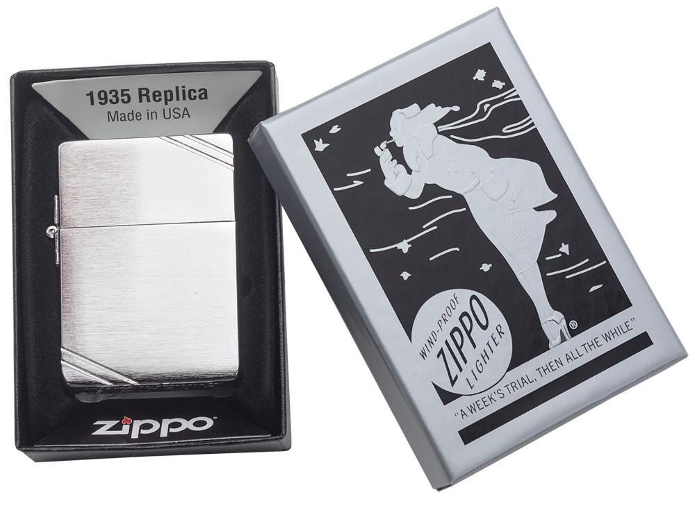 Zippo aansteker 1935 replica vooraanzicht in geborsteld chroom look met gegraveerde slashes op tegenoverliggende hoeken in open zwartgrijze geschenkverpakking