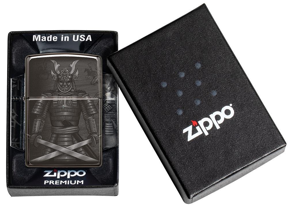 Vooraanzicht Zippo-aansteker zwart glanzend met samoeraikrijger met gekruiste zwaarden in open geschenkverpakking